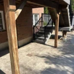 A patio featuring wooden stairs and a wooden railing, creating a warm and inviting outdoor space.